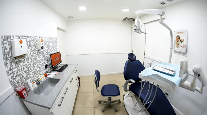 Consultorio con la mesada, el monitor con el logo y el sillón azul