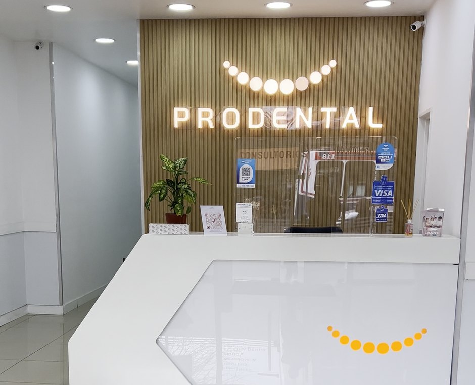 Recepción de una sucursal de Prodental, con el mostrador y el cartel iluminado de la marca